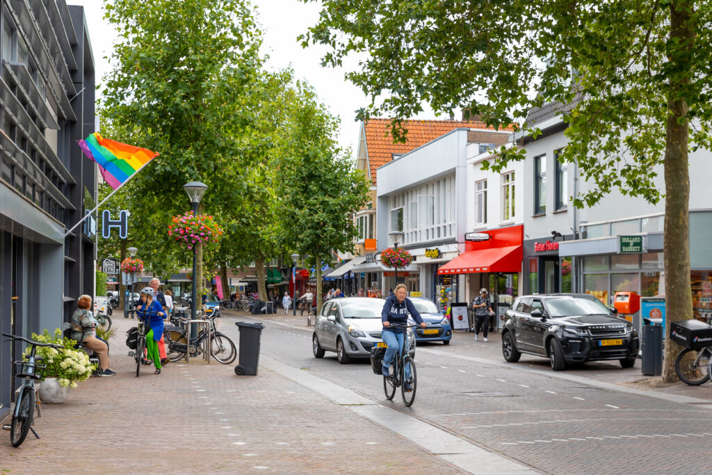 deen straat in bloemendaal. een fietser fietst voorbij en er rijdt een auto